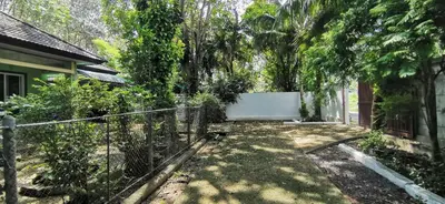 a fence in front of a house with a tree at Bassara House 2 bedroom in Koh Lone