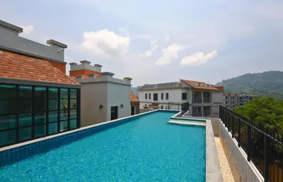 a swimming pool on the side of a house at 1 BR apartment in Title Naiyang in Nai Yang Beach