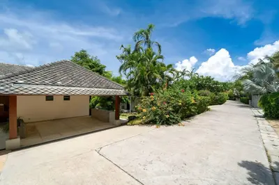 an empty driveway to a house with trees and flowers at \u5c71\u6d77\u306e\u5922 1600\u5e73\u8c6a\u534e\u79c1\u4eba\u6cf3\u6c60\u522b\u5885 15m\u8d85\u5927\u6cf3\u6c60 \u6b65\u884c\u6d77\u8fb9 \u514d\u8d39\u65e9\u9910 \u4f63\u4eba in Phuket Town