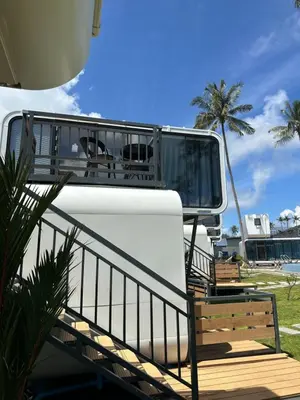 a white rv with a balcony and a bench at Space House Hotel Phuket in Rawai Beach