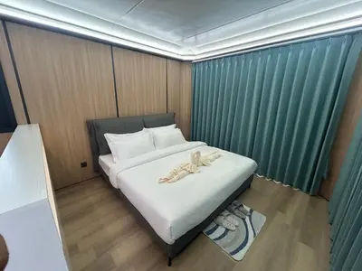 a small bedroom with a bed with white sheets at Space House Hotel Phuket in Rawai Beach