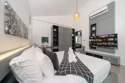 a bedroom with a white bed with pillows at \u6668\u6d77\u306e\u5922\u4e09\u5367\u79c1\u4eba\u82b1\u56ed\u6cf3\u6c60\u522b\u5885 in Ban Pak Lak