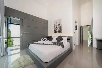 a large bedroom with a large bed with white sheets at \u6668\u6d77\u306e\u5922\u4e09\u5367\u79c1\u4eba\u82b1\u56ed\u6cf3\u6c60\u522b\u5885 in Ban Pak Lak