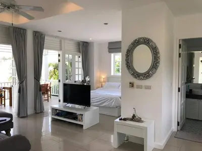 a living room with a bed and a mirror at Ocean breeze studio 1 bed in Ban Pak Lak