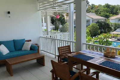 a porch with a couch and a table and chairs at Ocean breeze studio 1 bed in Ban Pak Lak