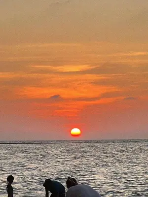 a group of people standing on a beach watching the sunset at Yada House s&h in Nai Yang Beach
