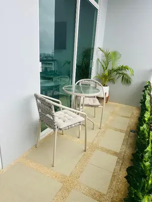 a patio with a glass table and chairs on a balcony at Apartment Karon SeaView 72 sq in Karon Beach