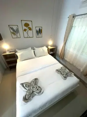 a bedroom with a bed with two flowers on it at Yada House s&s in Nai Yang Beach