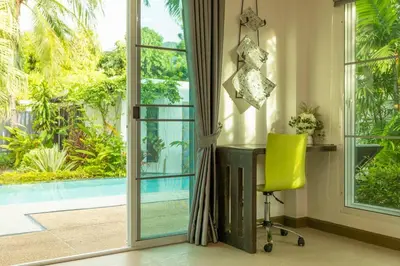 a yellow chair in a room with a sliding glass door at 15 Minuets Walk 2 BangTao Beach Fully Loaded v134 in Bang Tao Beach