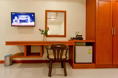 a room with a desk with a chair and a mirror at Phaithong Sotel Resort in Chalong