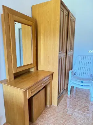 a wooden dresser with a mirror and a blue chair at Mood Resotel Kamala in Kamala Beach