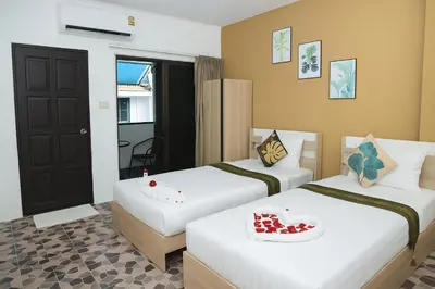 a hotel room with two beds and a door at Burning Flame Patong in Patong Beach