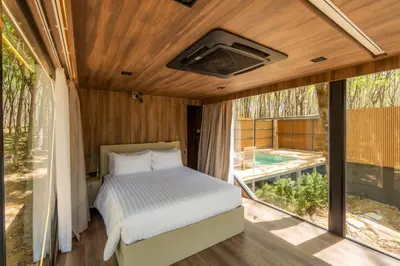 a bedroom with a bed and a large window at Timber Society Boutique Hideaway in Phuket Town