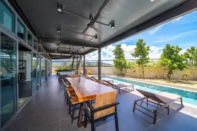 a dining room with a table and chairs and a pool at BangTao 6-bedroom villa 18 meters, competition-grade swimming pool, industrial style design aesthetic, gaming and entertainment floor, suitable for family vacations and group gatherings in Bang Tao Beach