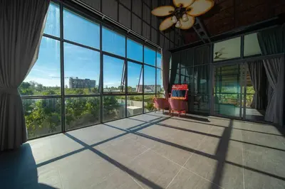 a large room with a ceiling fan and large windows at BangTao 6-bedroom villa 18 meters, competition-grade swimming pool, industrial style design aesthetic, gaming and entertainment floor, suitable for family vacations and group gatherings in Bang Tao Beach