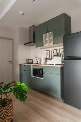 a kitchen with green cabinets and a refrigerator at Title Halo Orange Sunset 46m2 Naiyang Pool&Gym in Nai Yang Beach