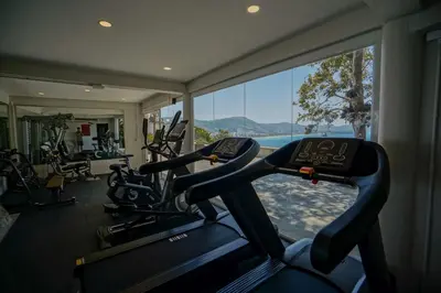 a gym with cardio machines and a large window at Anona Sunset Boutique in Karon Beach