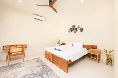 a white bedroom with a bed and a piano at Kokyang Estate by TropicLook in Nai Harn Beach