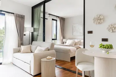 a white room with a bed and a couch and a table at Title Halo Modern Line Pool View Gym Sauna in Nai Yang Beach