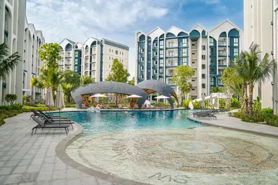 a large swimming pool in a resort with buildings at Title Halo Modern Line Pool View Gym Sauna in Nai Yang Beach