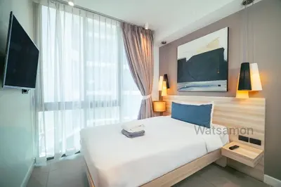 a bedroom with a large white bed and a large window at Oceanstone Condo 2 bedrooms BangTao Laguna in Bang Tao Beach