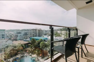 a balcony with two chairs and a view of the city at the beach height resort by sahana in Kata Beach