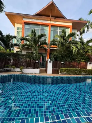a house with a swimming pool in front of a house at Kamala Evergreen Home in Kamala Beach