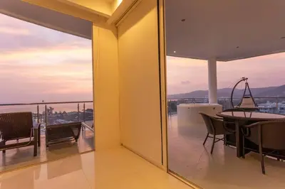 a balcony with a dining table and a view of the ocean at Best View In Phuket! 2 Living Rooms 4 BR #C80 in Karon Beach