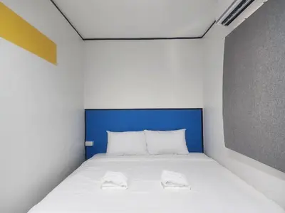 a bedroom with a bed with two towels on it at RYB Hostel Phuket in Ban Lo Long