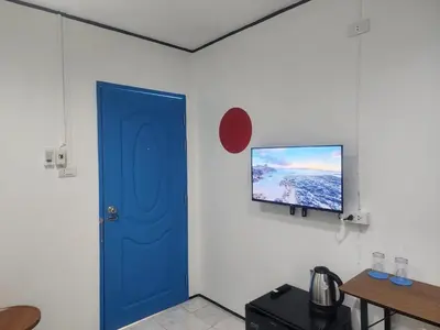 a blue door in a room with a tv on the wall at RYB Hostel Phuket in Ban Lo Long