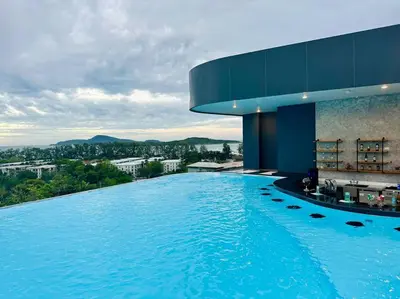 a large swimming pool in front of a building at La Vita Stylish apartment in 5 star hotel in Rawai Beach