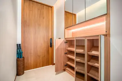 a walk in closet with wooden cabinets and a door at Banyan Tree Grand Residences by Banyan Living in Phuket Town
