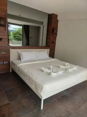 a white bed with two white flowers on it at The green golf resident 106 in Kathu