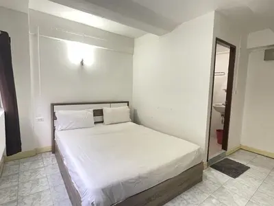 a white bed in a room with a mirror at Nice to CU Guest house in Patong Beach
