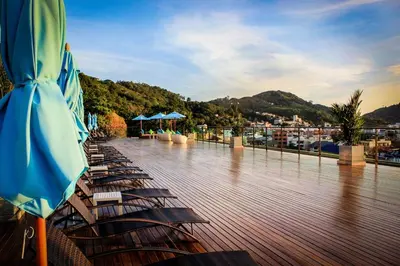 a row of chairs and umbrellas on a deck at Villa Noon in Patong Beach