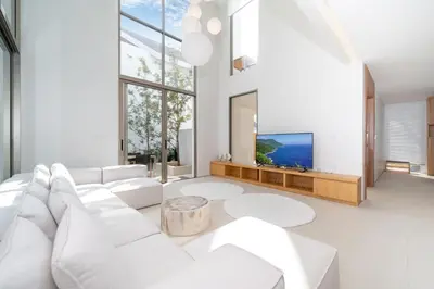 a living room with a white couch and a tv at Sofia Villa Phuket in Phuket Town