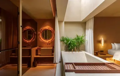 a bedroom with a tub and a bed with mirrors at Café del Mar Phuket - Suite & Penthouse in Kamala Beach