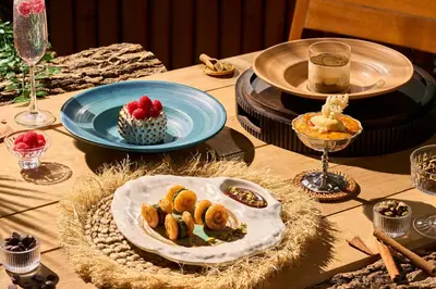 a table topped with plates of food on a table at Café del Mar Phuket - Suite & Penthouse in Kamala Beach
