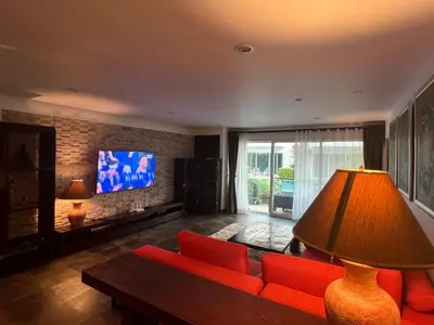 a living room with a red couch and a tv at VILLA AP Grand Residence in Kamala Beach