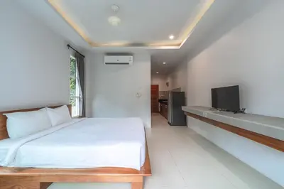 a bedroom with a bed and a tv on a wall at Little Kamala Hill in Kamala Beach