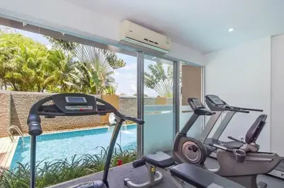 a gym with two exercise bikes next to a swimming pool at Chic Condominium Karon B511 in Karon Beach