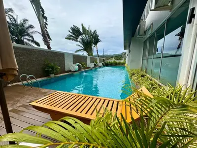 a swimming pool with a wooden bench next to a building at Chic Condominium Karon B307 in Karon Beach