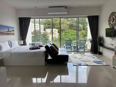 a bedroom with a large bed and a large window at Chic Condominium Karon B307 in Karon Beach
