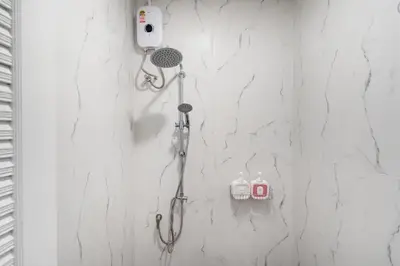 a shower in a bathroom with white marble walls at Seven Heaven Patong Villa in Patong Beach