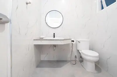 a white bathroom with a toilet and a mirror at Seven Heaven Patong Villa in Patong Beach