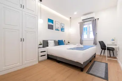 a white bedroom with a bed and a desk at Seven Heaven Patong Villa in Patong Beach