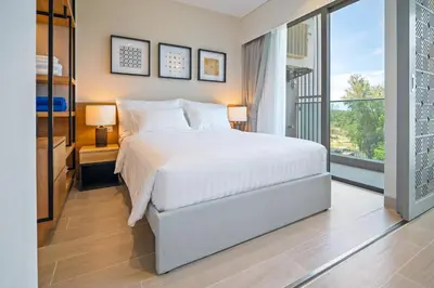 a bedroom with a bed and a large window at Laguna Lakeside Residences by Banyan Living in Laguna Phuket