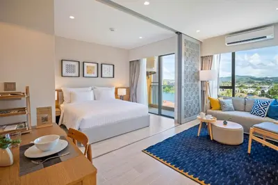 a bedroom with a bed and a living room at Laguna Lakeside Residences by Banyan Living in Laguna Phuket