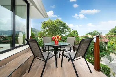 a patio with a table and chairs on a deck at patong hill villa 3 in Patong Beach