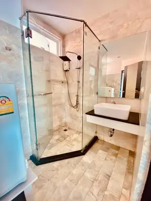 a bathroom with a shower and a sink at Stunning 60 sqm Studio at NaiHarn Beach Condo, Walk to Beach, Your Tropical Retreat! in Rawai Beach
